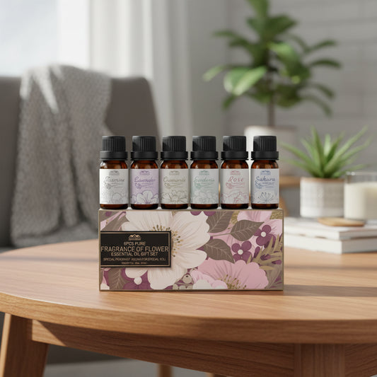 Set of six essential oil bottles with floral labels and a decorative box in the background.