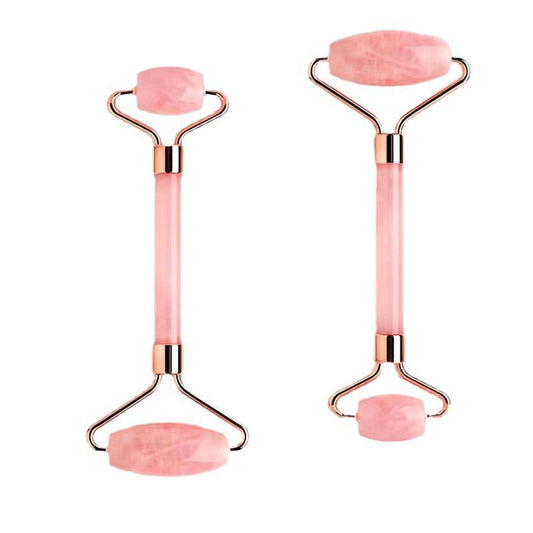 Two pink facial rollers with rose gold handles on a white background