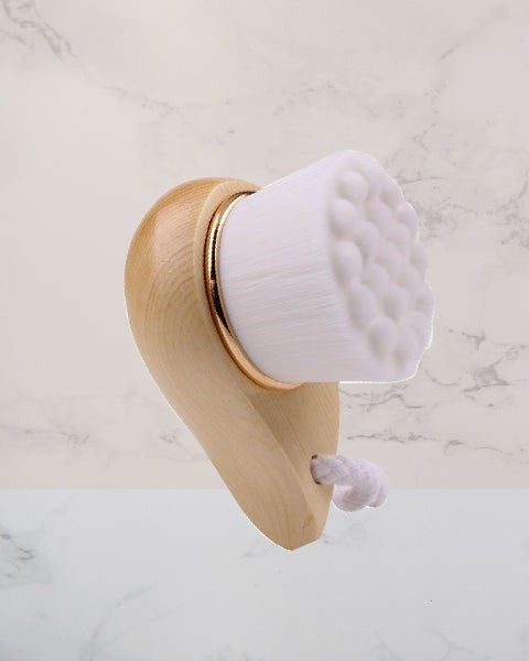 Wooden face brush with white bristle head on a marble background