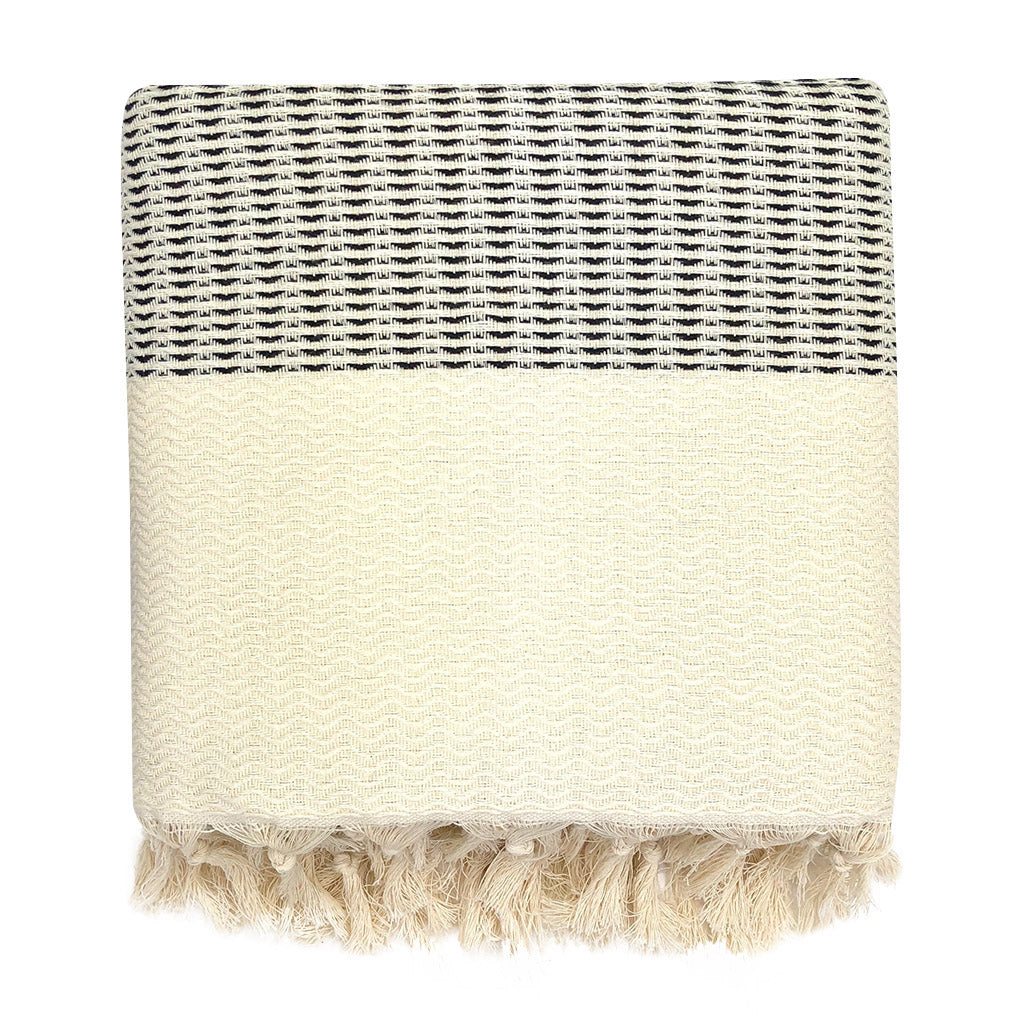 Woven blanket with black and white stripes and tassels on a white background