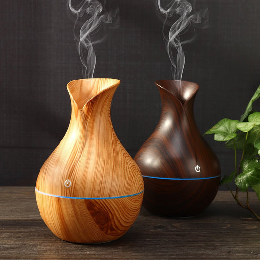 Two wooden diffusers emitting steam on a dark background