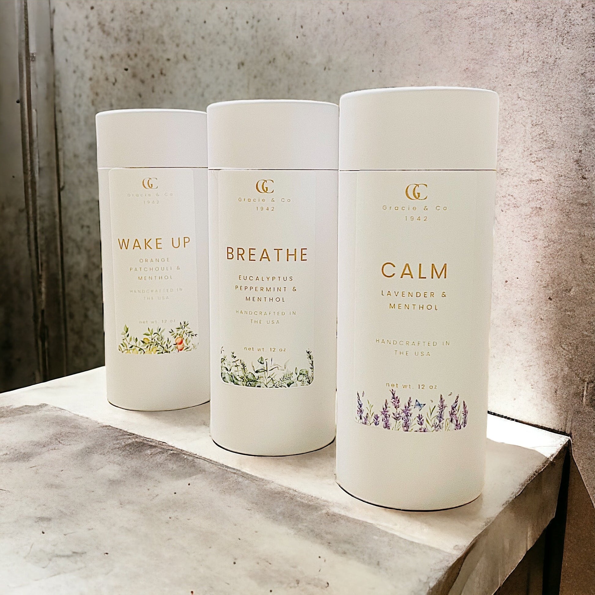 Three white cylindrical containers labeled 'Wake Up', 'Breathe', and 'Calm' on a marble surface.